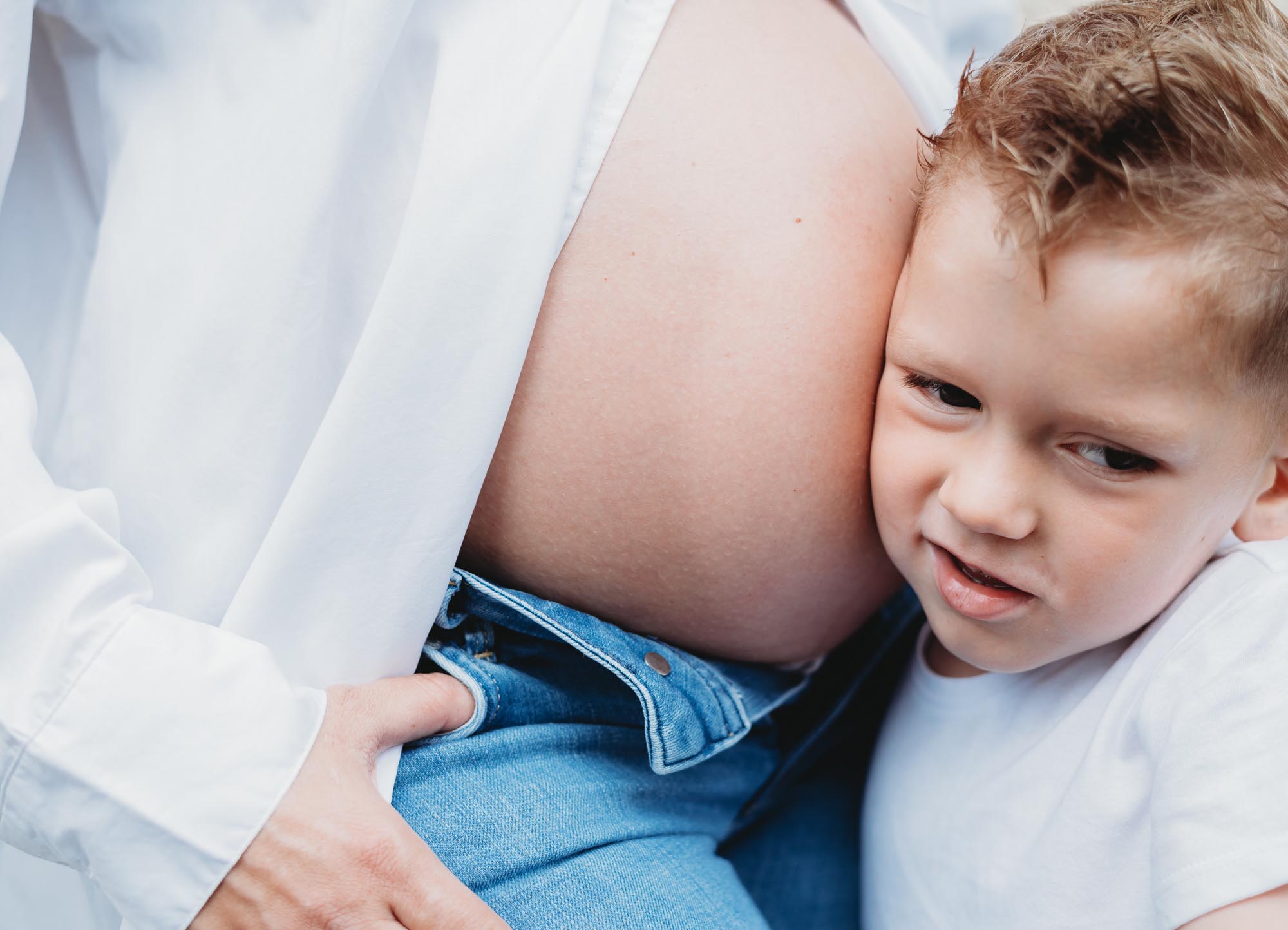 Babybauch-Schwangerschaftsshooting in Wien - Kleiner Junge hört am Babybauch von Mama