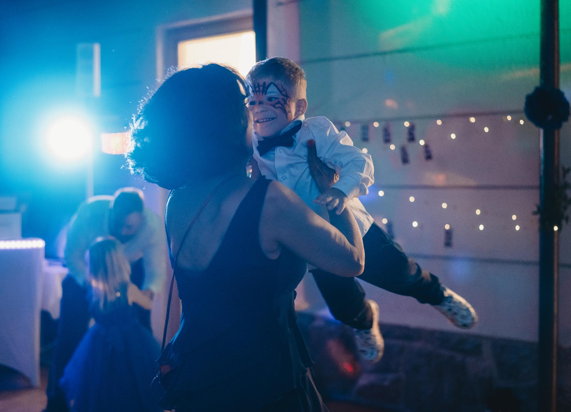 Hochzeitsfotos_Hochzeitsreportage in Wien_Feier_Oma tanzt mit Enkel schwingend durch die Luft
