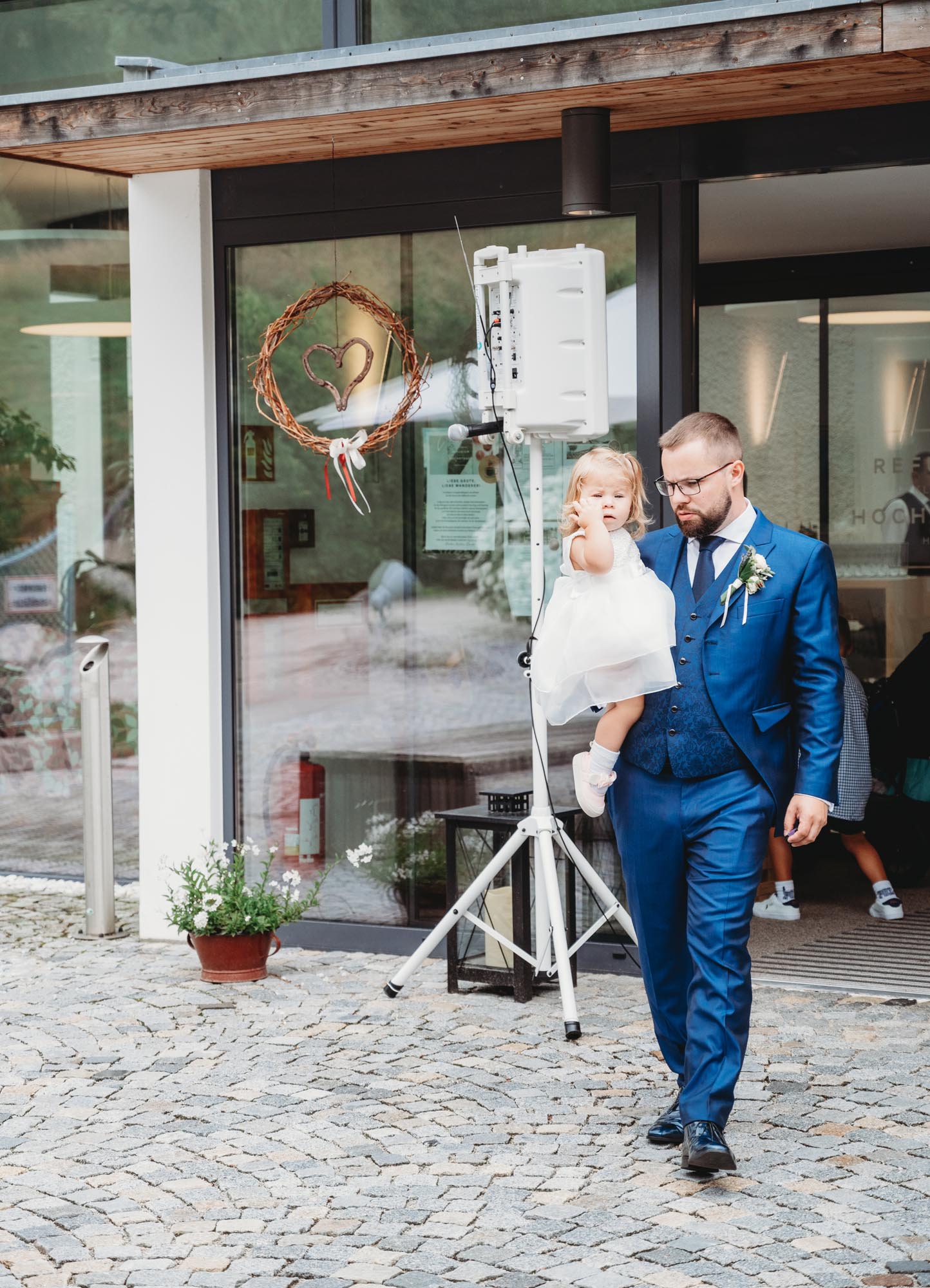 Hochzeitsfotos_Hochzeitsreportage in Wien_Feier_Bräutigam trägt Tochter auf dem Arm