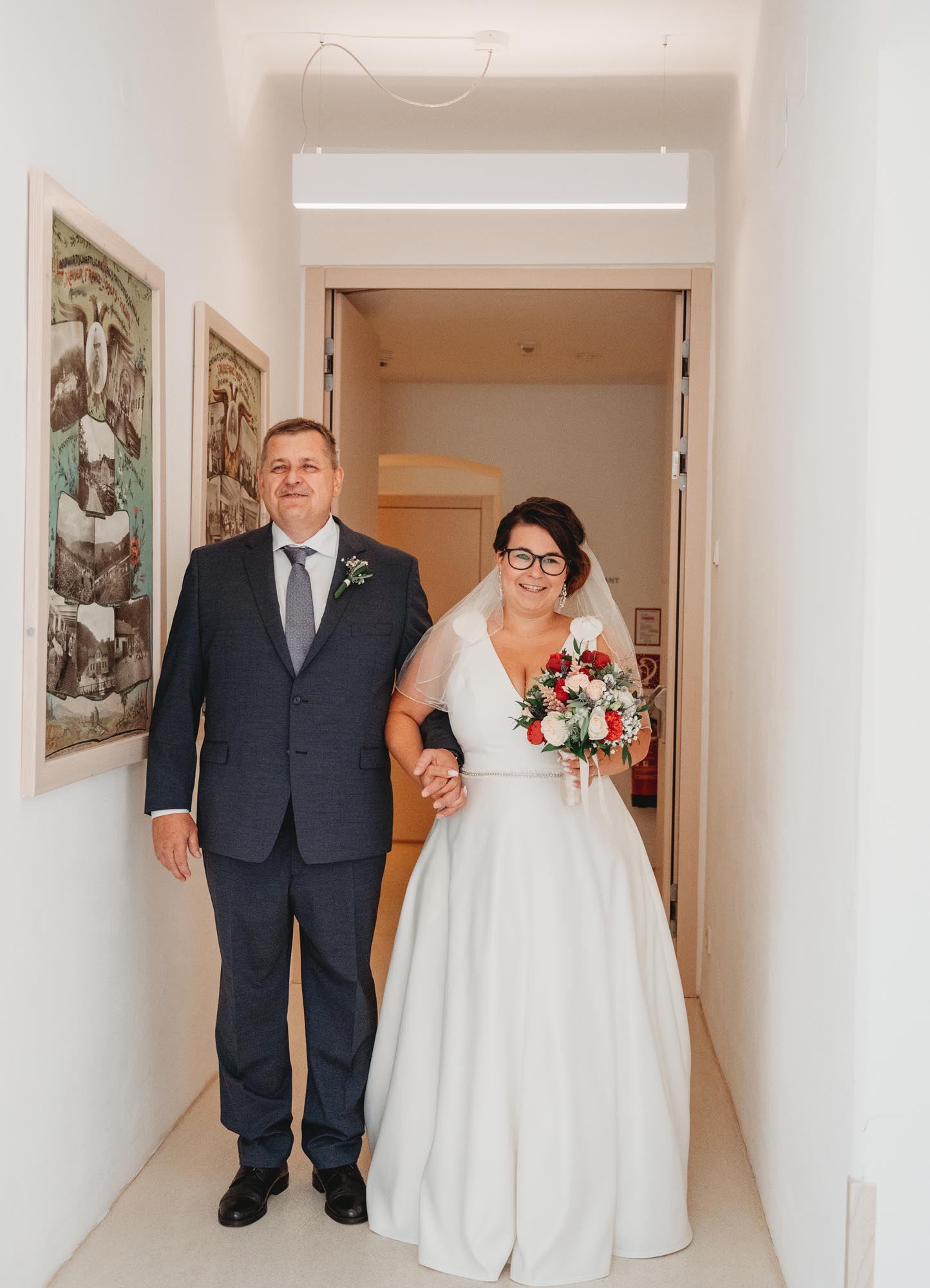 Hochzeitsfotos_Hochzeitsreportage in Wien_Trauung_Braut steht mit Schwiegerpapa und wartet strahlend auf den Einzug