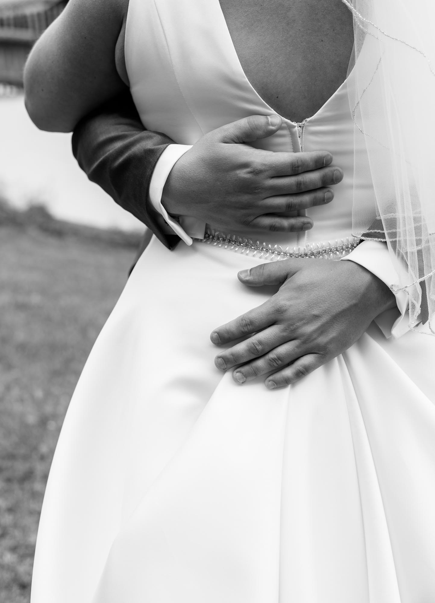 Hochzeitsfotos_Hochzeitsreportage in Wien_FirstLook_CloseUp Bräutigam umarmt Braut Aufnahme von hinten