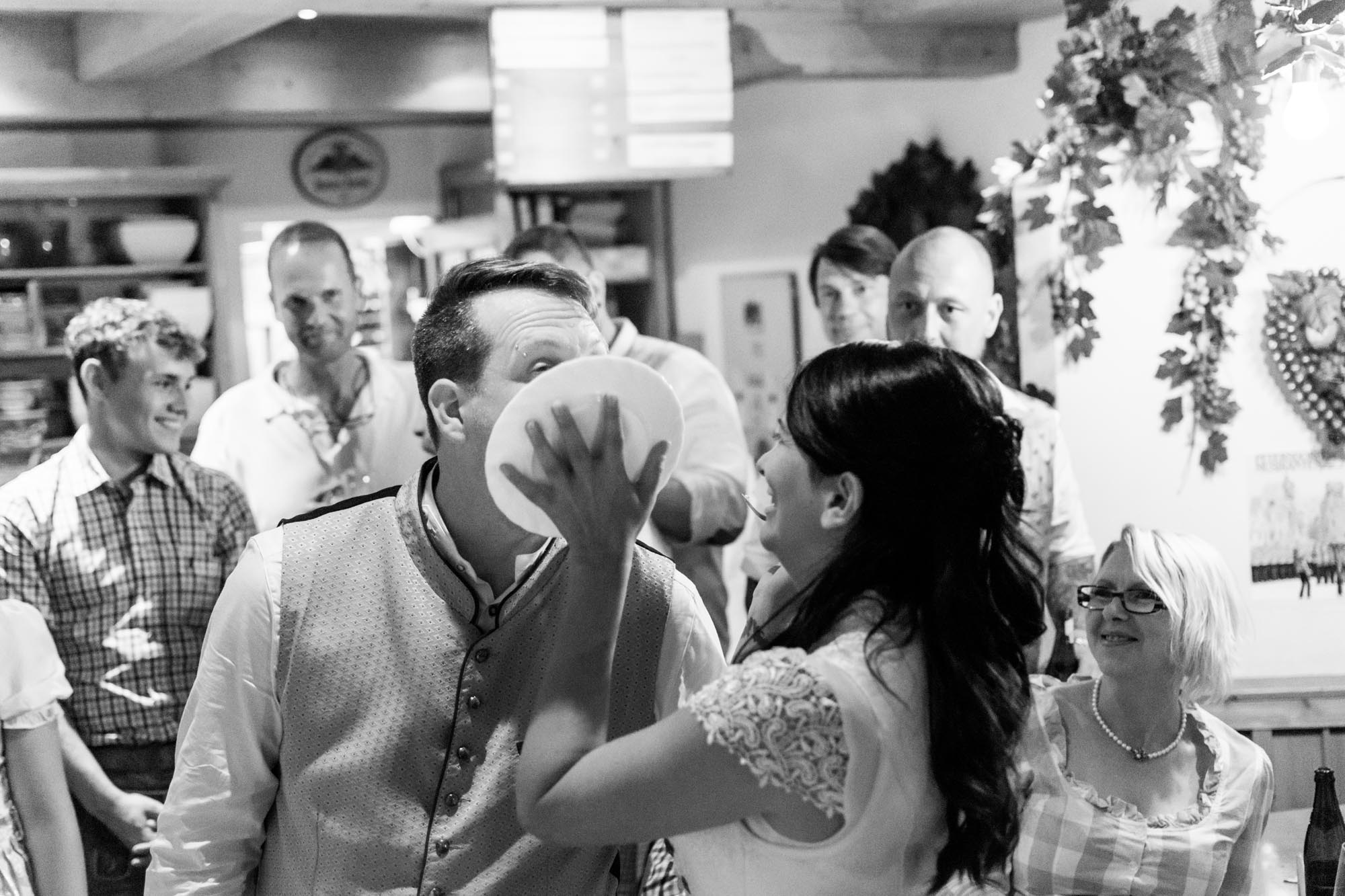 Hochzeitsfotos_Hochzeitsreportage in Wien_Hochzeitstorte_Braut drückt Bräutigam Teller mit Hochzeitstorte ins Gesicht