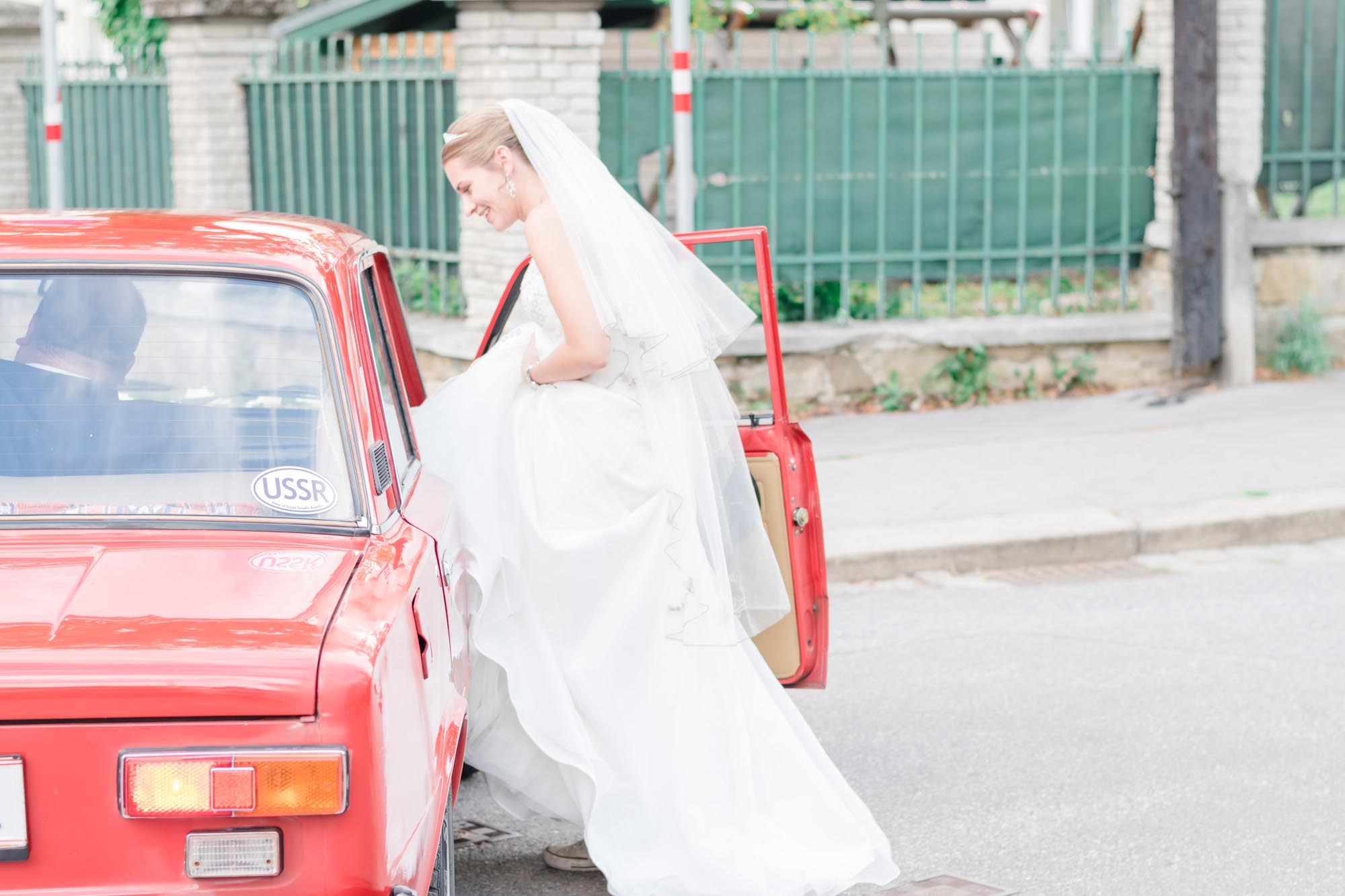 Hochzeitsfotos_Hochzeitsreportage in Wien_Braut steigt in den Wagen ein