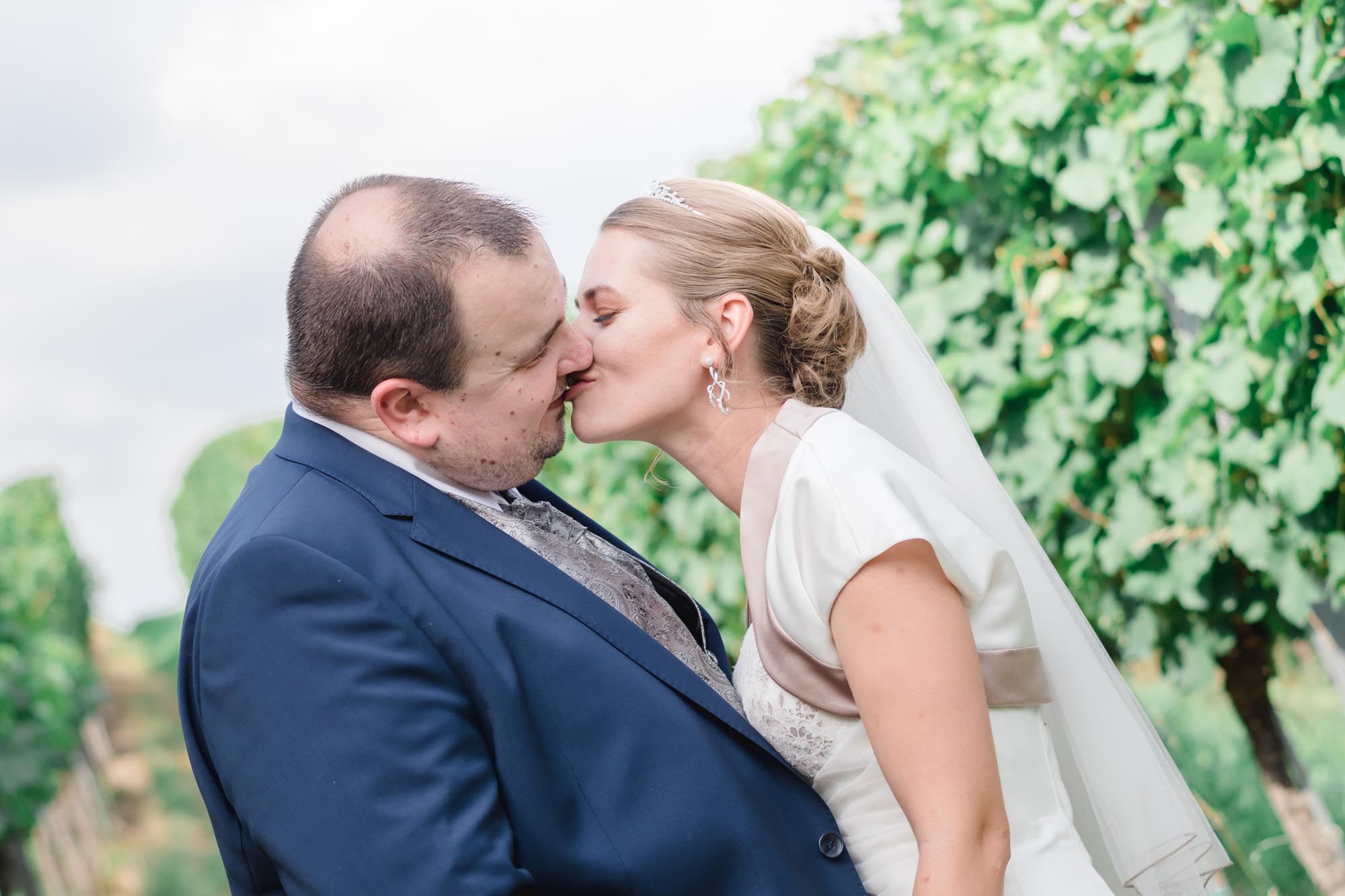 Hochzeitsfotos_Hochzeitsreportage in Wien_Brautpaarshooting_Brautpaar küsst sich in den Weinbergen