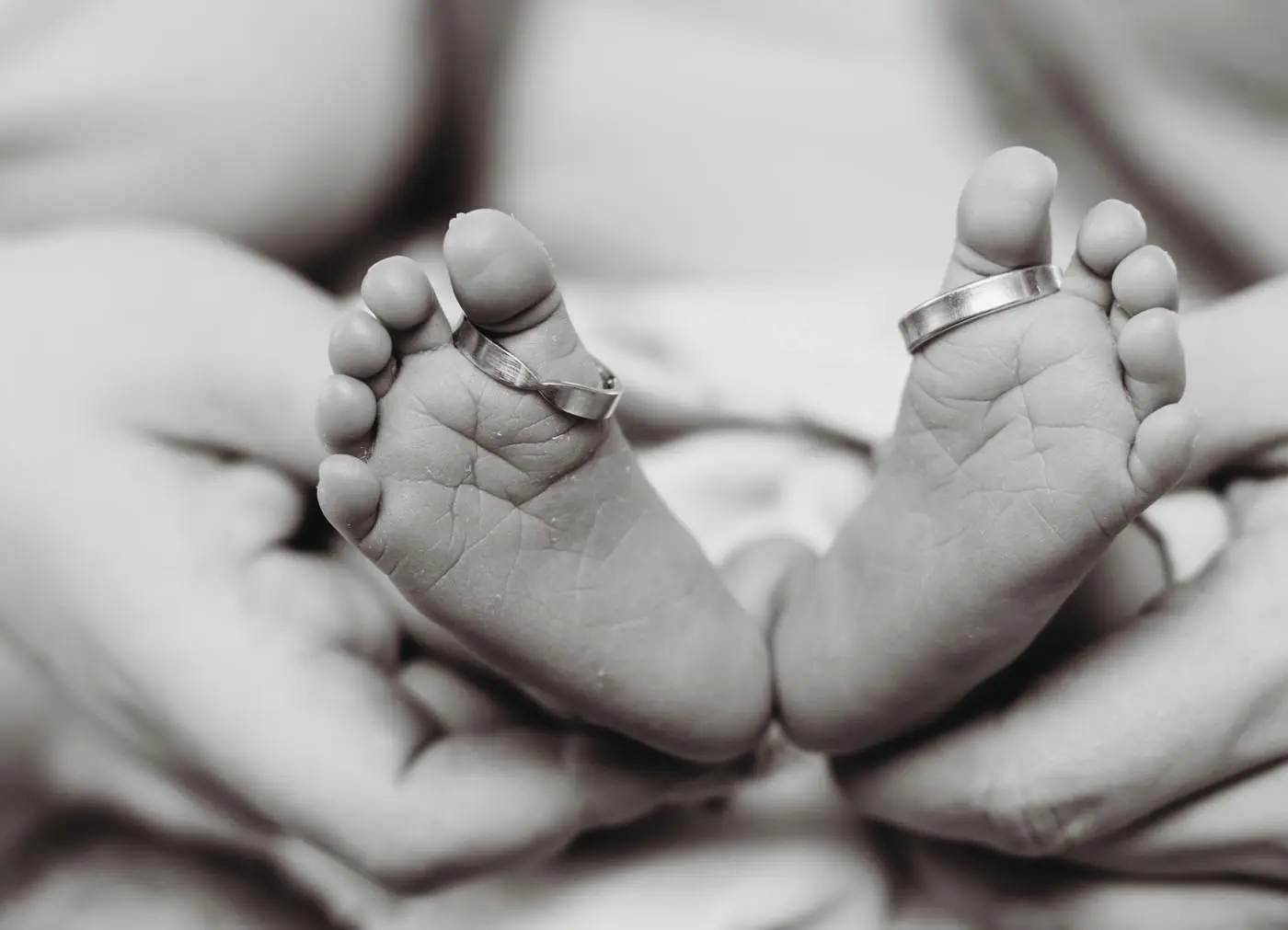 Großaufnahme Babyfüße mit Eheringen auf Zehen