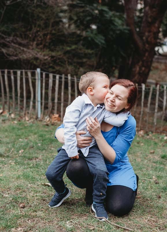 Kind küsst Mama auf die Wange beim Muttertags-Fotoshooting in Wien