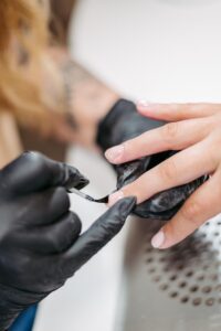 Businessreportage: Nageldesignerin trägt grad die letzte Schicht Lack auf