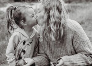 Mama und Tochter geben sich ein Bussi