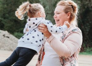 Oma und Enkelin spielen gemeinsam und die Oma dreht ihre Enkelin in der Luft