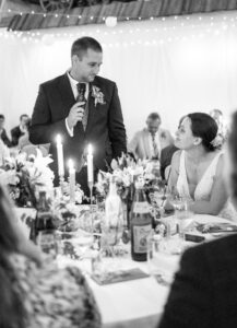 Bräutigam hält eine Rede und schaut dabei ganz verliebt seine Braut an
