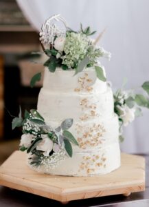 Hochzeitsstorte weiß mit weißen Blumen und goldenen Akzenten