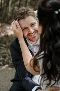 Die Braut streicht ihrem Ehemann durch die Haare und er strahlt sie ganz verliebt an