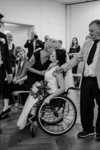 Brautmutter gibt ihrer Tochter als Braut einen Kuss auf die Wange bei der Übergabe an den Bräutigam