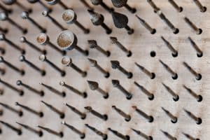 Nahaufnahme auf Werkzeug (Bohrer) eines Goldschmieds. Die Bohrer stecken in einer Platte