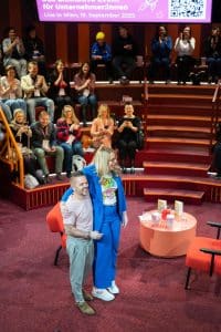 Buinessreportage_Veranstaltungsreporte: Live Video Podcast von Corinna Hintenberger mit Stefan Verra im socialhub Wien. Corinna Hintenberger & Stefan Verra verabschieden sich Arm in Arm vom Publikum und verlassen im Anschluss den raum