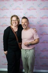 Buinessreportage_Veranstaltungsreporte: Live Video Podcast von Corinna Hintenberger mit Stefan Verra im socialhub Wien. Stefan Verra lässt sich im Anschluss an die Veranstaltung mit Publikum vor einer Fotowall fotografieren und lacht herzlich